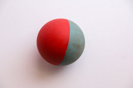 Red and green rubber dog ball on white background